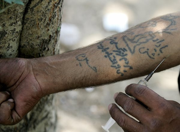 Un chauffeur de camion iranien injecte de l'héroïne dans un parc à Téhéran - AFP/Getty Images