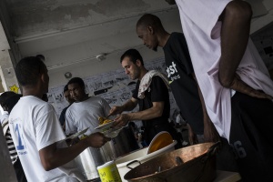 Around 300 migrants settled in disused  school Guillaume Bud in central Paris. Afghan migrant is distributing food. FRANCE 13/08/2015